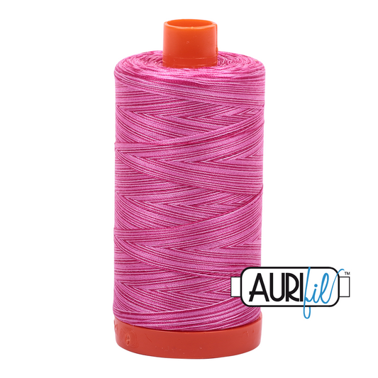 Spool of pink thread with orange ends on a white background, featuring the Aurifil logo.